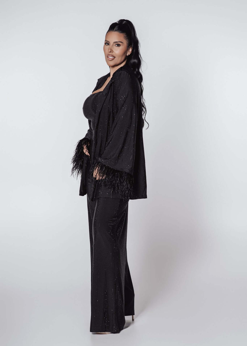 Compleu Bling Miray negru din lycra cu cristale, bustieră, pantaloni evazați și mantou elegant cu pene, model de seară
