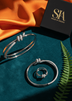 set brățară și inel cu nod și cristale, argintiu cu pietre strălucitoare, prezentare elegantă pe fundal textil