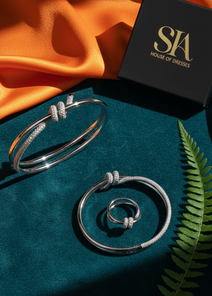 set brățară și inel cu nod și cristale, argintiu cu pietre strălucitoare, prezentare elegantă pe fundal textil