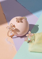 Set SIA Floral Embrace, brățară și inel aurii cu design floral și cristale, prezentate pe fundal pastel elegant