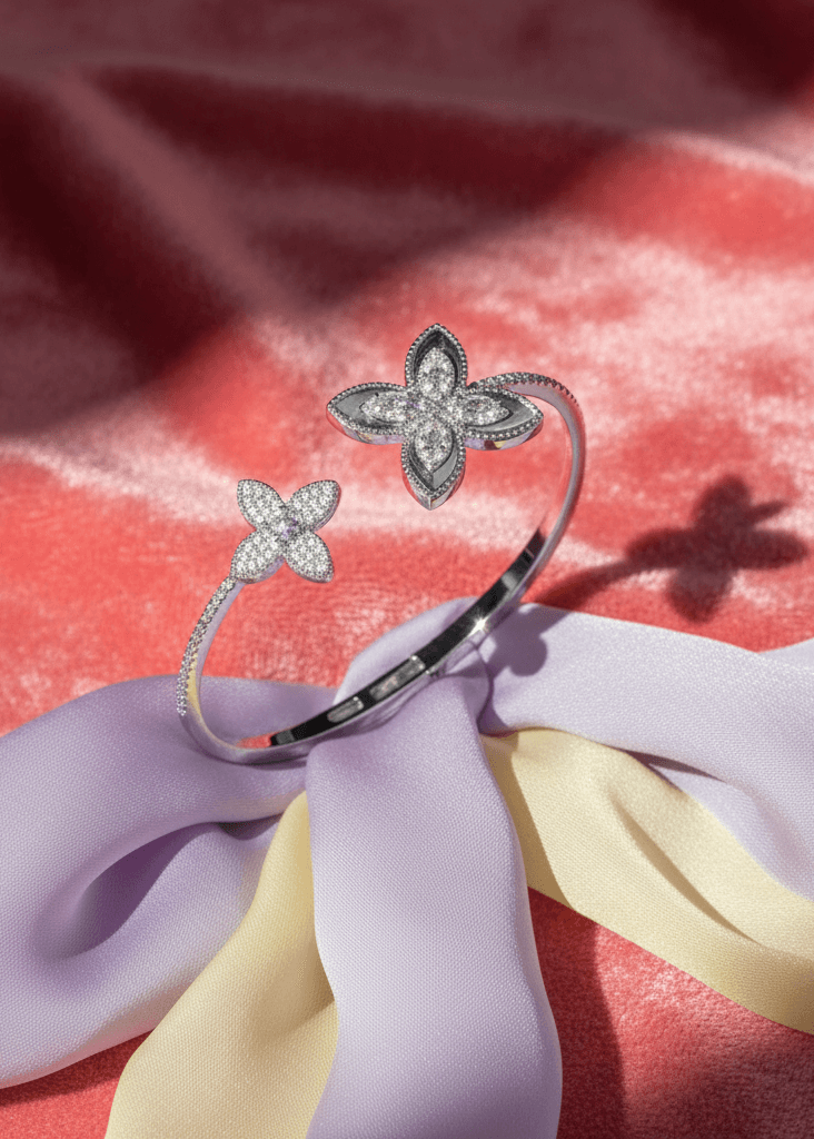 Set SIA Floral Embrace brățară deschisă cu design floral și cristale, afișată pe fundal din satin roz și panglică lila-galbenă