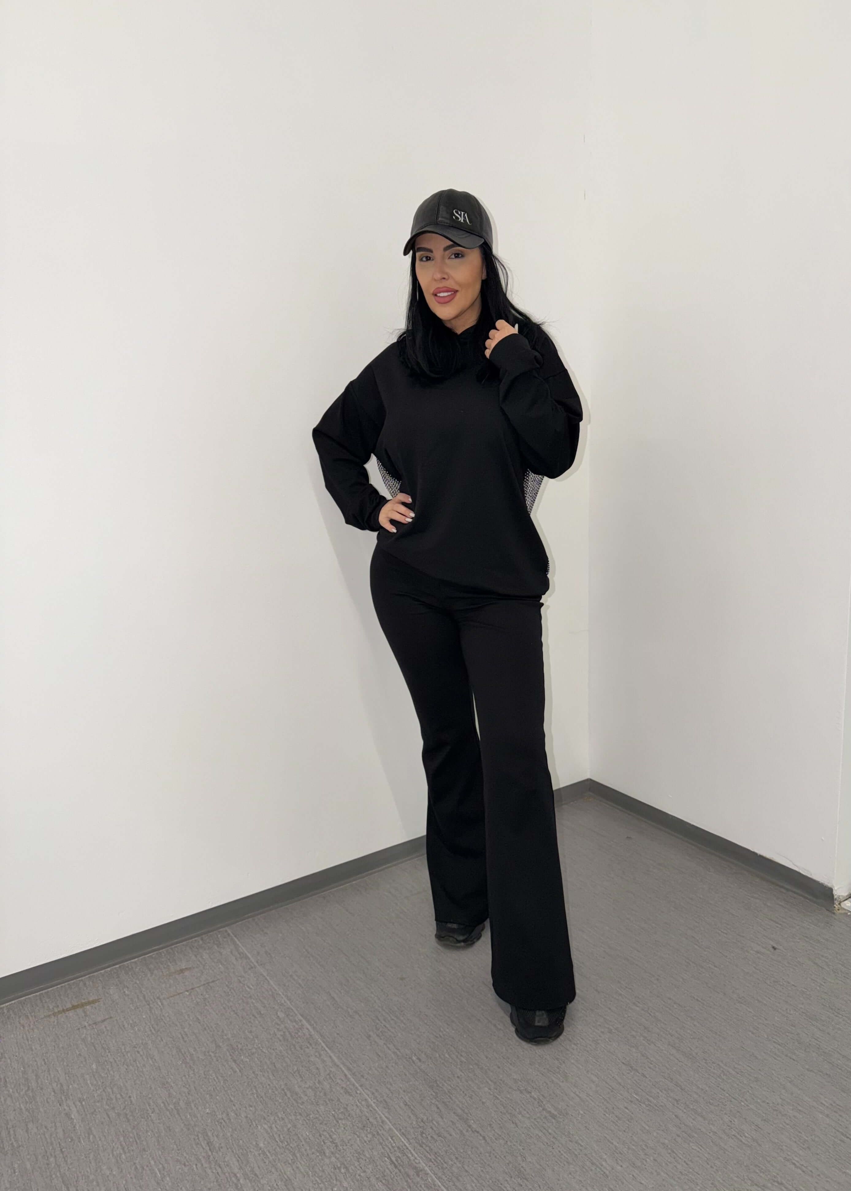 Model poartă pantaloni pentru trening "FLARE" de la SIA, cu talie înaltă și croi evazat, pentru un look modern. Cuvânt cheie: pantaloni. Main image