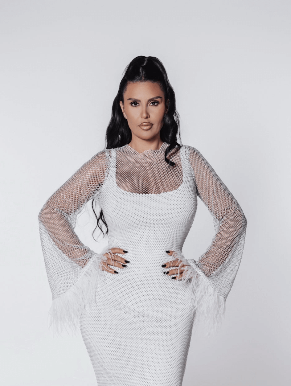 Rochie scurtă Bling Diva cu plasă, cristale și mâneci decorate cu pene, purtată de model.