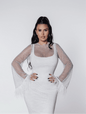 Rochie scurtă Bling Diva cu plasă, cristale și mâneci decorate cu pene, purtată de model.