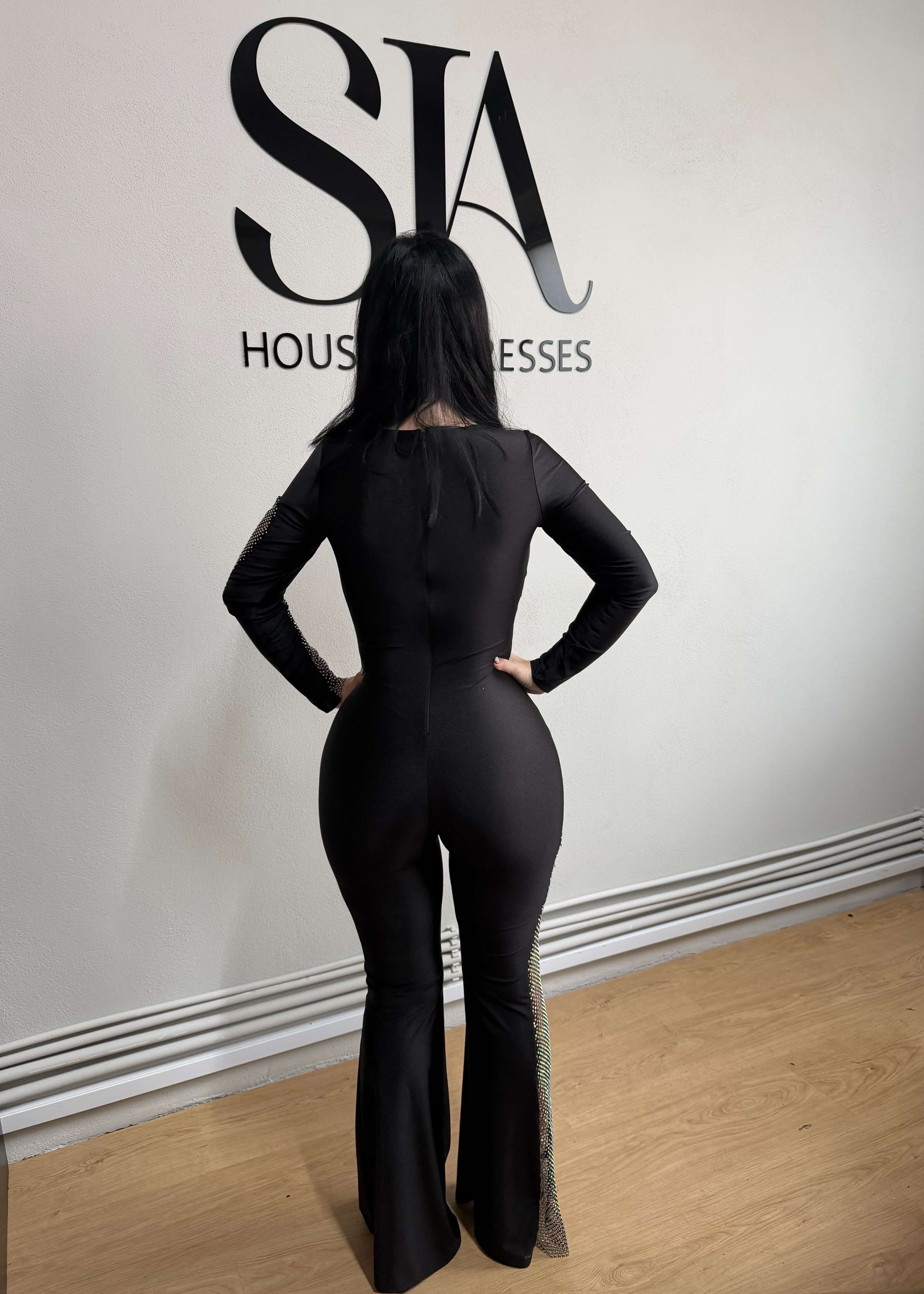 Salopetă neagră din lycra "GLAMOROUS" cu plasă strălucitoare, vedere din spate în showroom SIA House of Dresses.