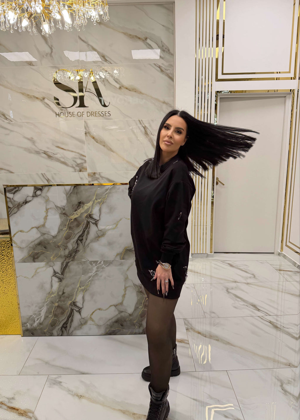 Femeie purtând SIA "ATTITUDE" hoodie în showroom elegant