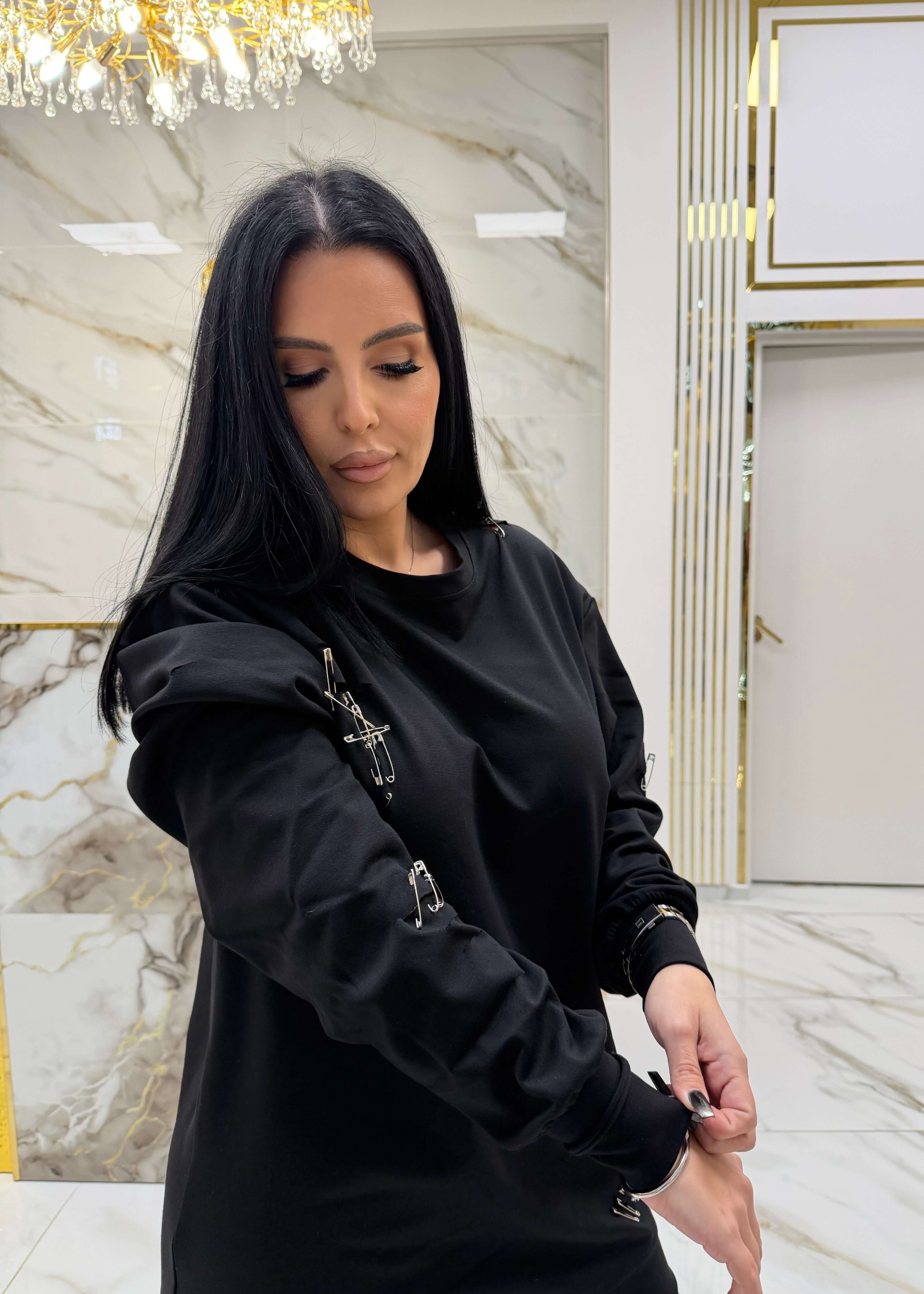 Hoodie negru "ATTITUDE" cu ace metalice, purtat într-o cameră cu decorațiuni luxoase