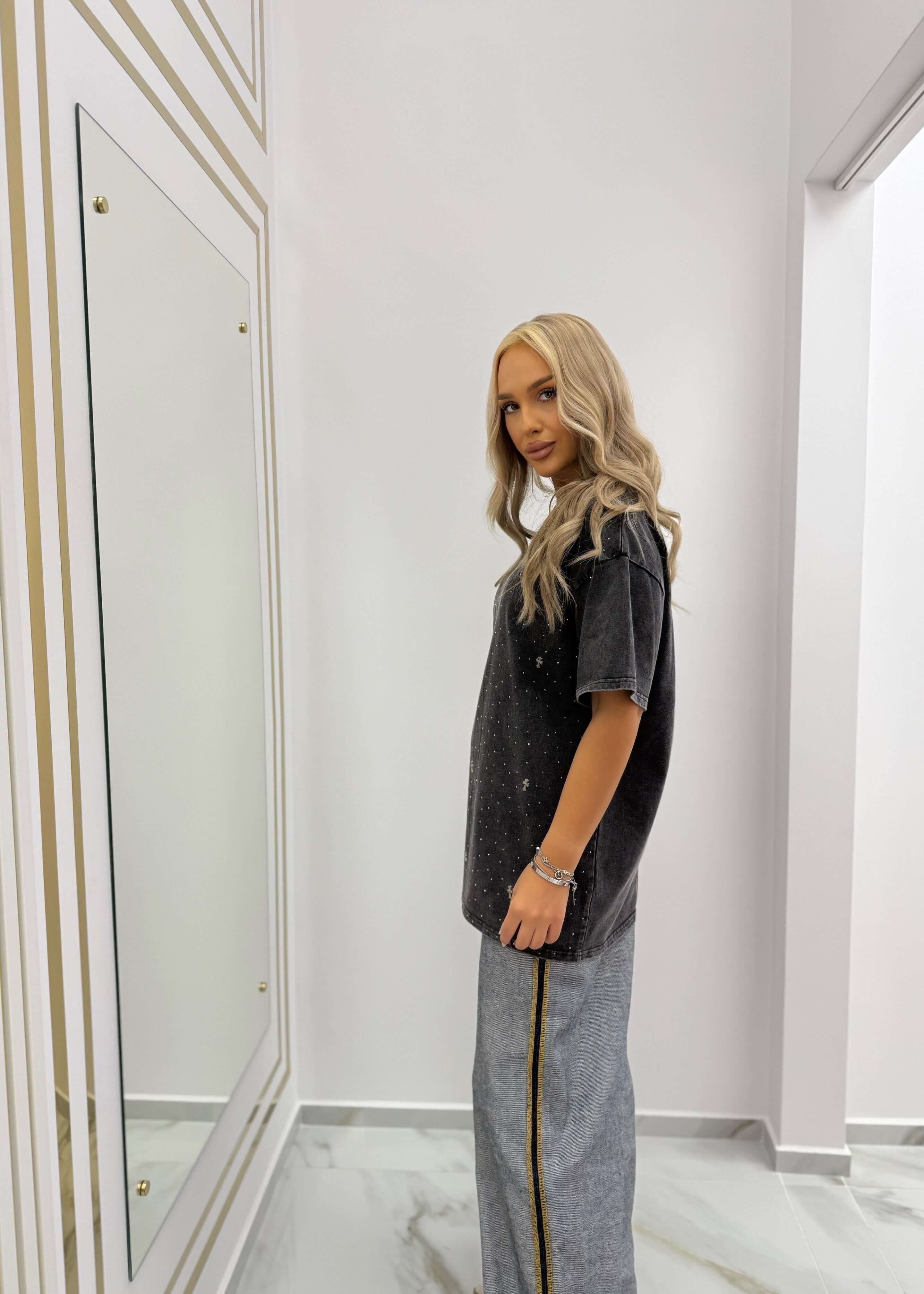 Tricou oversized SIA "RELIGION" cu efect washed și accente strălucitoare, purtat cu pantaloni gri cu dungi laterale aurii