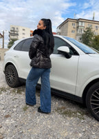 Geaca WINTER ARMOR cu guler îmblănit detașabil, matlasată, impermeabilă și rezistentă la vânt, purtată lângă un SUV alb