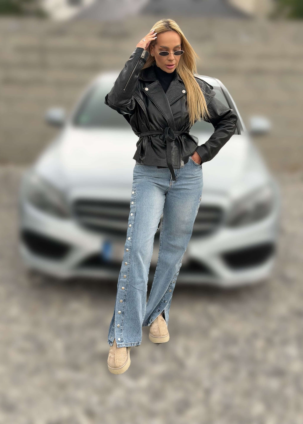 Blugi cu capse laterale SNAP ME, outfit urban cu jachetă din piele neagră în fața unei mașini