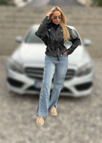 Blugi cu capse laterale SNAP ME, outfit urban cu jachetă din piele neagră în fața unei mașini