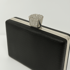 Geanta clutch neagră elegantă cu detalii argintii și textură rafinată pentru ținute glam și minimaliste, curea bijuterie strălucitoare.