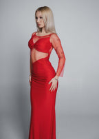 Rochie roșie lungă tip evening dress, croială mulată cu decupaj talie, purtată de model blond pe fundal gri neutru