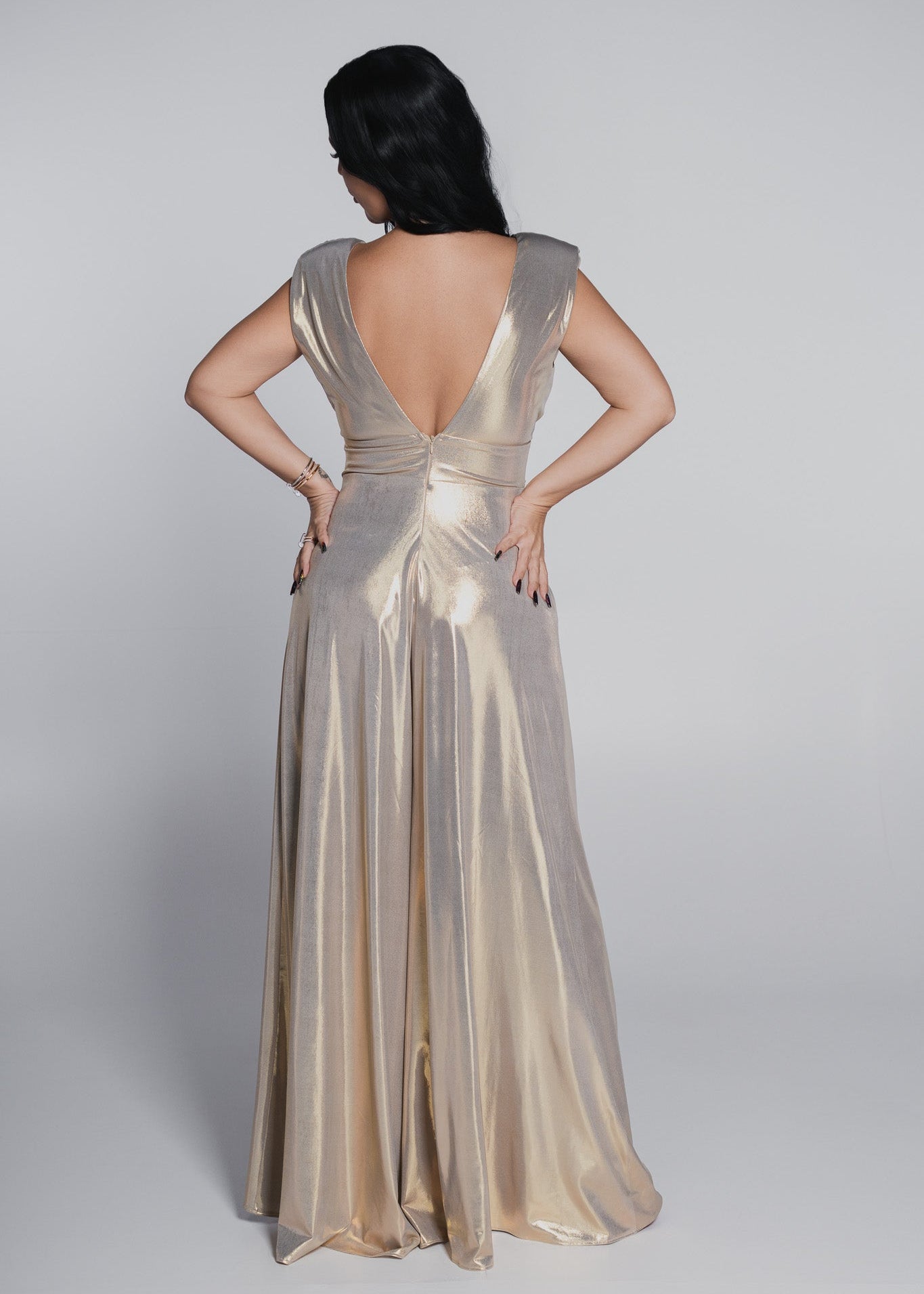 Salopeta Bling Illusion Estera din lycra metalizată aurie, cu spatele gol adânc, vedere din spate pe fundal gri