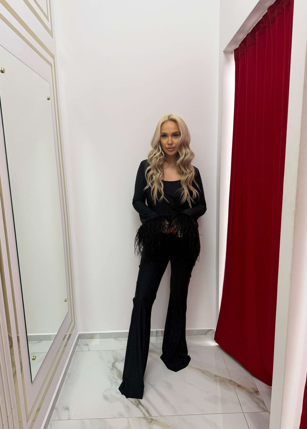 Salopeta Bling Temptation neagră, cu cristale și mâneci evazate cu pene, modelând silueta unei femei elegante